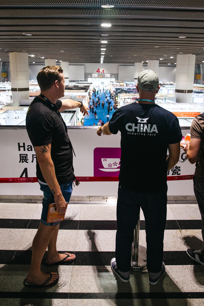 Lyden pointing out suppliers at Canton Fair with China Scouting Trip attendee
